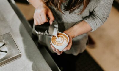 barista pouring milk on coffee