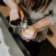 barista pouring milk on coffee