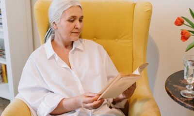 woman reading a book while sitting on a chair