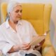 woman reading a book while sitting on a chair