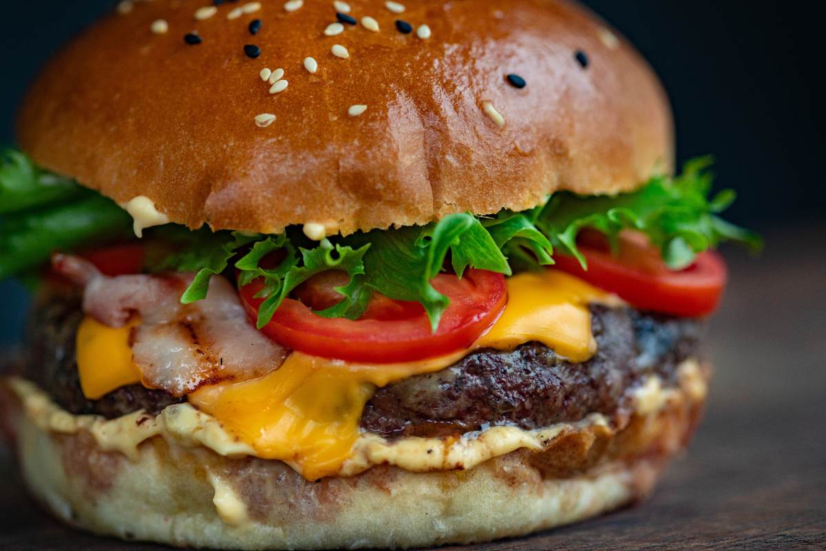 close up photo of hamburger with lettuce tomato bacon and cheese