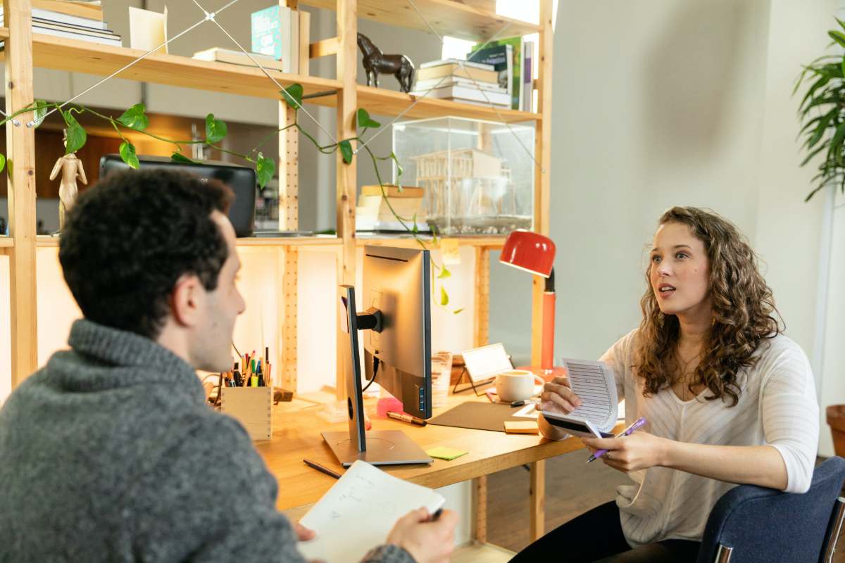 two people holding a notebook and pen