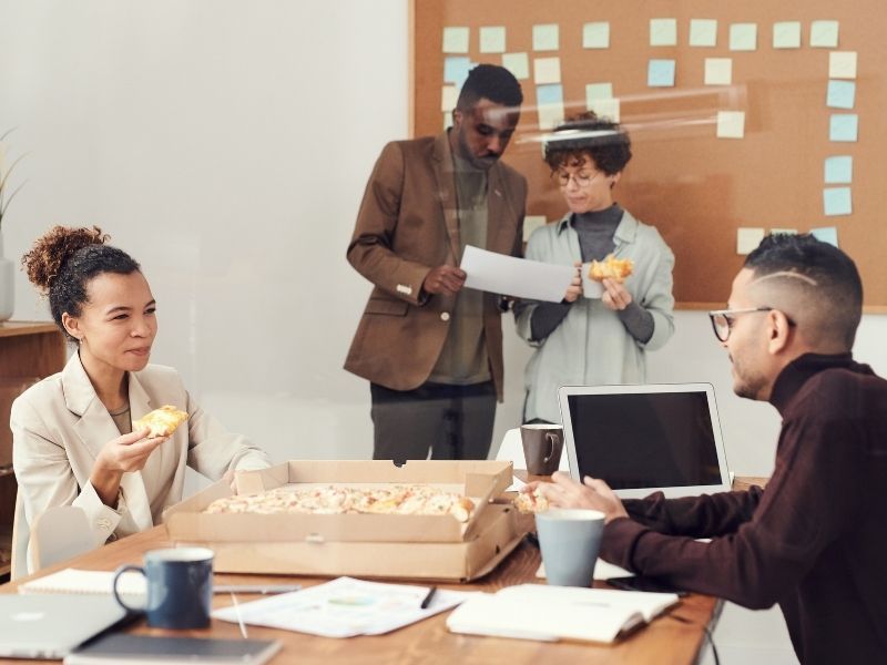 people having pizza in the office