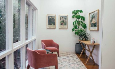 room with chairs plants and paintings