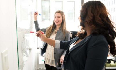 two women writing on a whiteboard