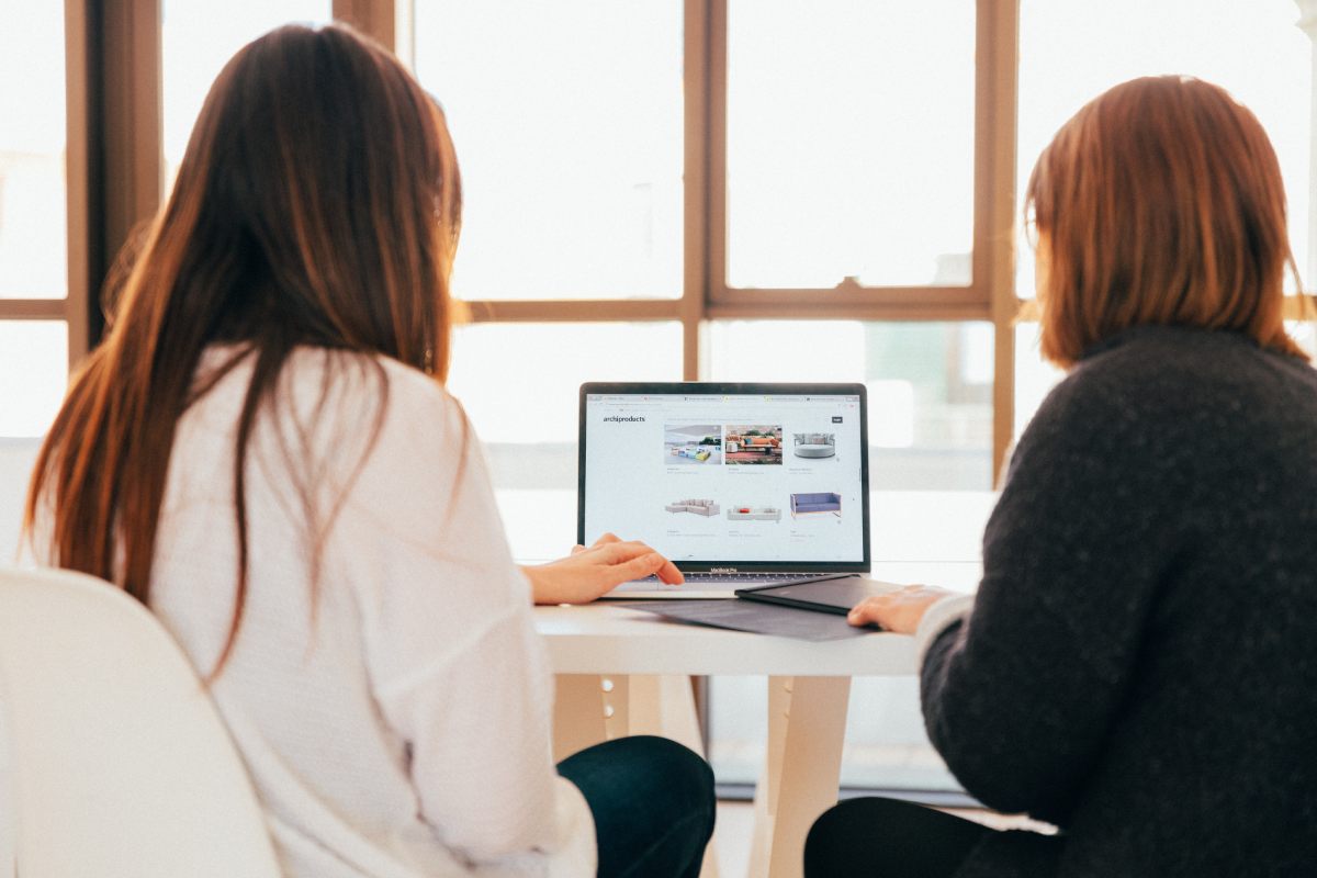 two women looking on a laptop screen